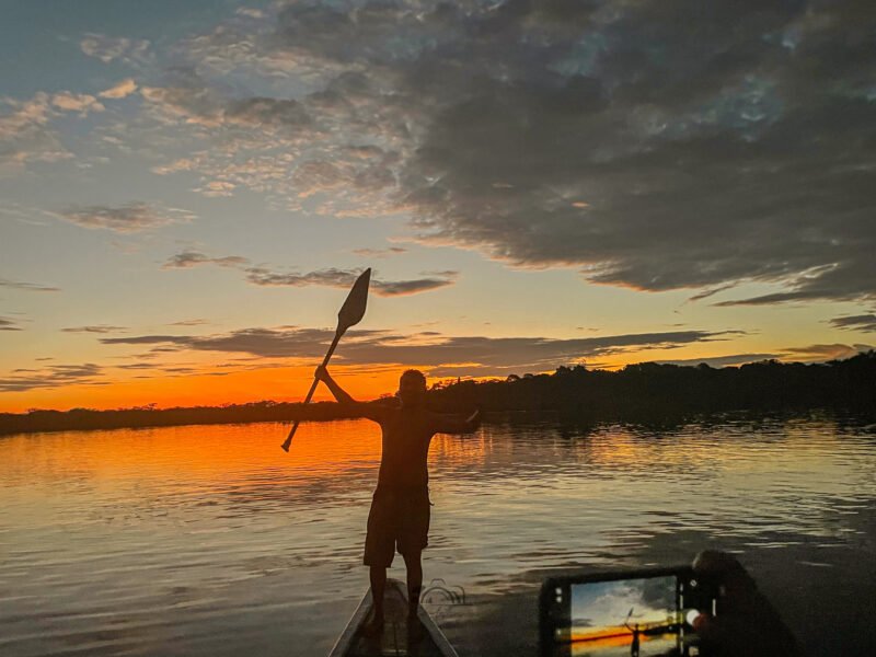 Paddler silhouetted against the sunset on the Cuyabeno lagoon