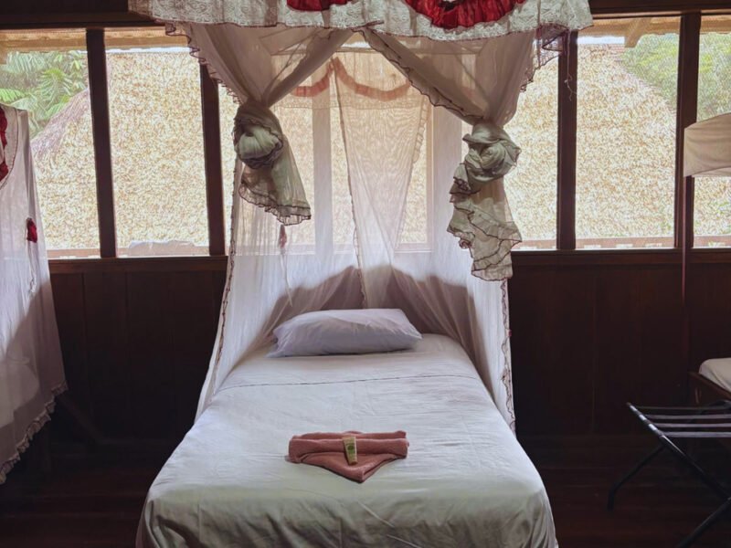 Single room with mosquito net at Cuyabeno Dolphin Lodge